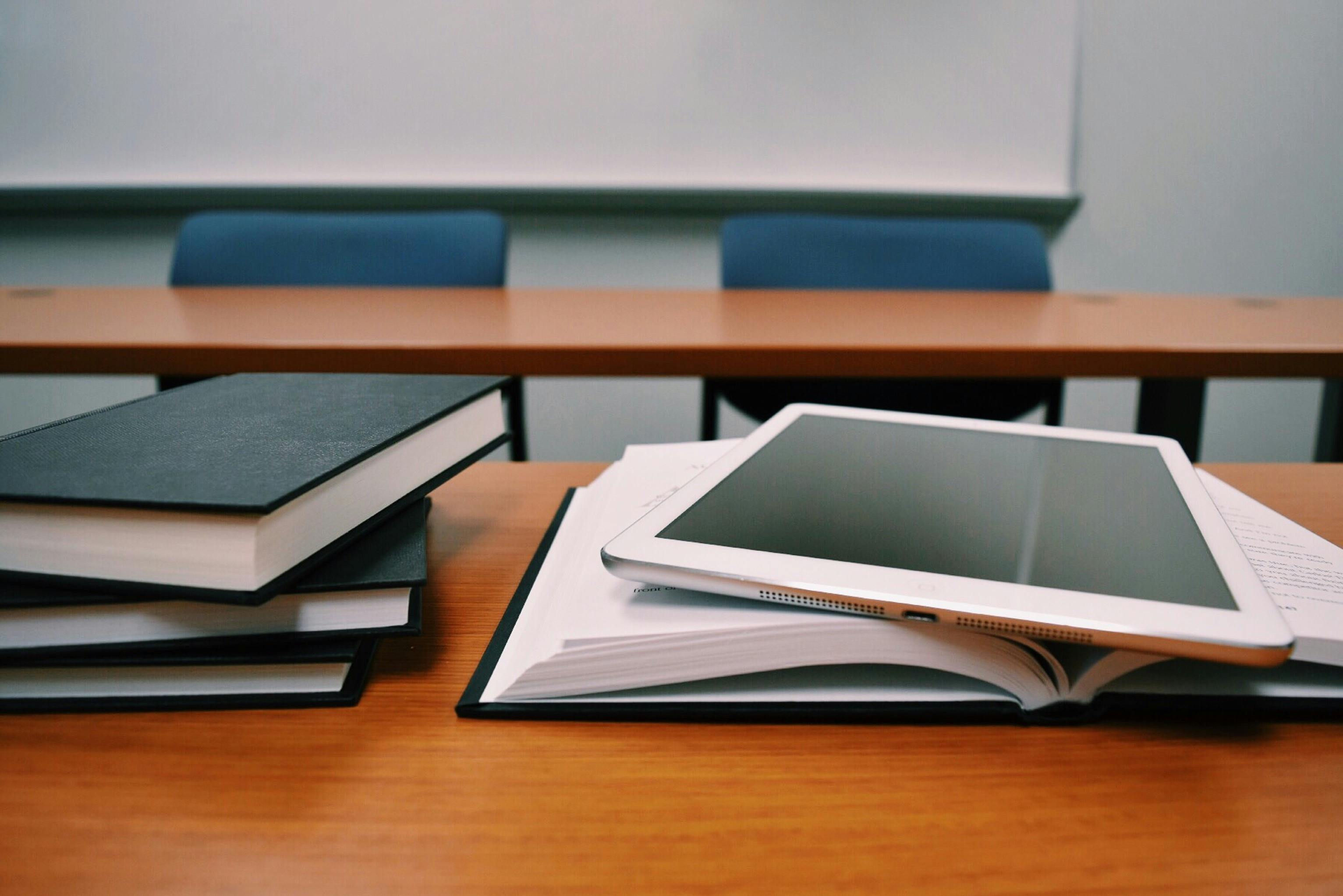 Books and a tablet on a table representing educational resources supported by grants